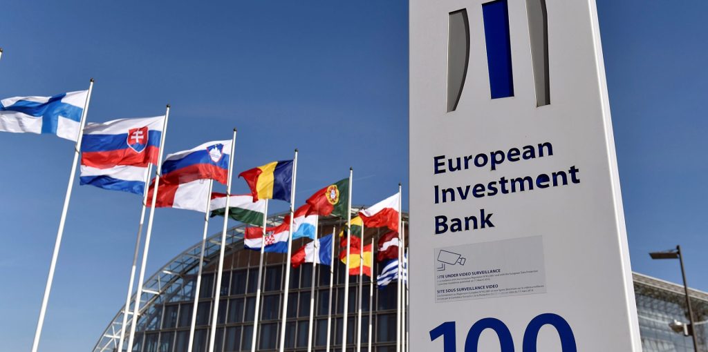 Flags are seen behind the logo of the European Investment Bank is pictured in the city of Luxembourg, Luxembourg, March 25, 2017. Reuters/Eric Vidal - RTX32PVY